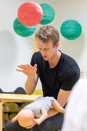 Spädbarn HLR docka används av instruktör för att visa HLR-tekniker i klassrumsmiljö.